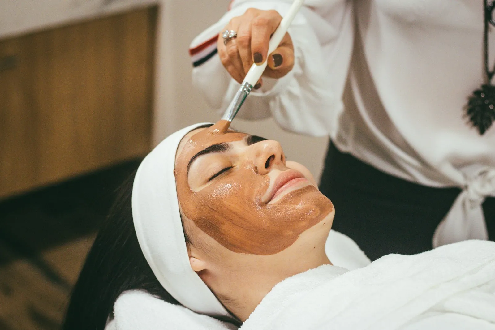 A woman relaxing with glowing, healthy skin after a beauty treatment
